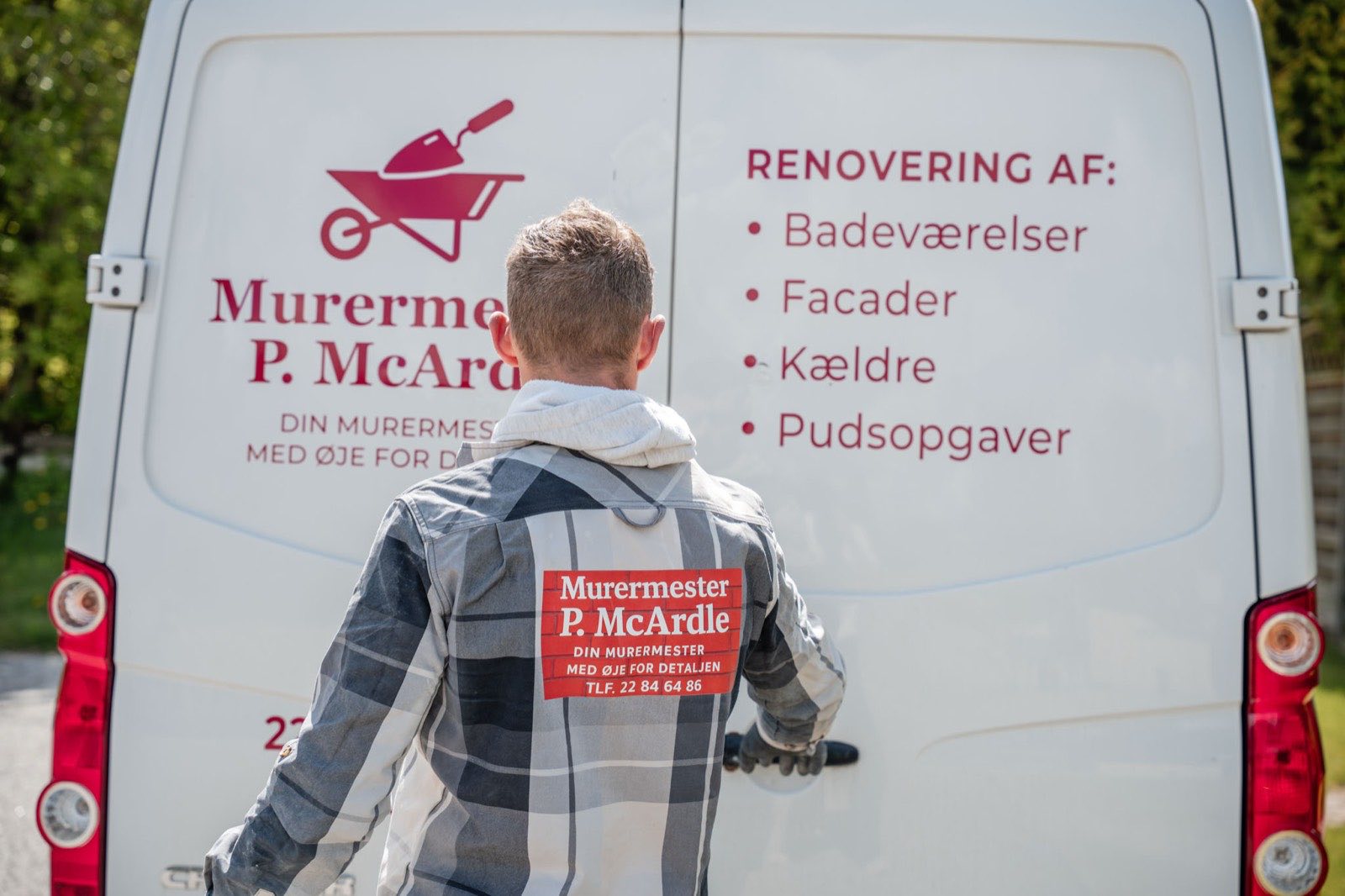 Murermester ved varevognen med logo og liste over ydelser